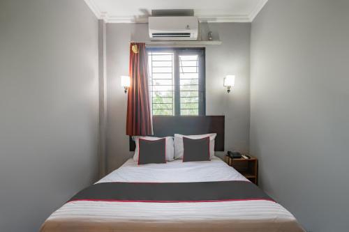 a bedroom with a large bed with a window at Collection O Pusat Kota Pekanbaru Near Mall Ska Formerly Hotel Olgaria in Pekanbaru