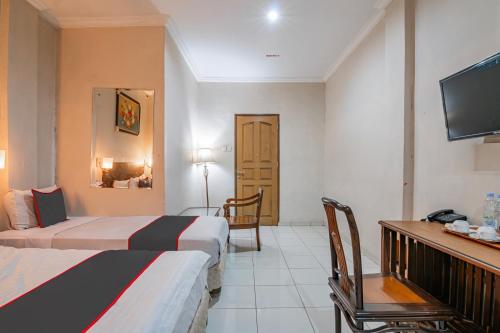a hotel room with two beds and a television at Collection O Pusat Kota Pekanbaru Near Mall Ska Formerly Hotel Olgaria in Pekanbaru