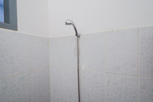 a shower in a bathroom with gray tiles at Hotel O Pdl Guest House Syariah in Cimahi