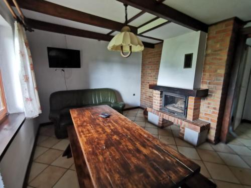 a living room with a wooden table and a fireplace at Ośrodek Wypoczynkowy "U Kulasa" in Warchały