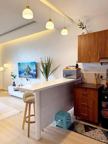 a kitchen with a white counter and a table at Lakeview Condo at Pearl marina Garuga in Kagolomolo