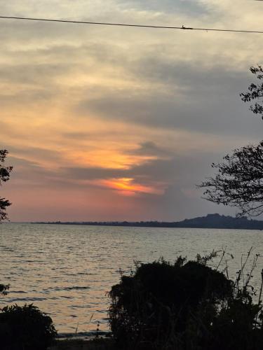 a sunset over a large body of water at Lakeview Condo at Pearl marina Garuga in Kagolomolo