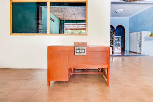 a wooden desk sitting on a floor in a room at Hotel O Homestay Arva in Wonosari