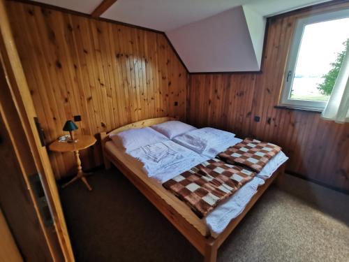 a bedroom with a bed in a wooden wall at Ośrodek Wypoczynkowy "U Kulasa" in Warchały