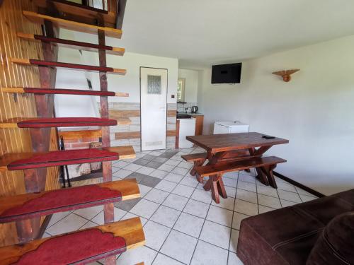 a living room with wooden stairs and a table at Ośrodek Wypoczynkowy "U Kulasa" in Warchały