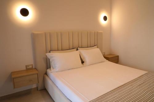 a bedroom with a white bed with two pillows at Vila Murati in Ksamil