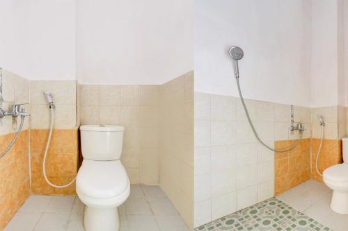 a bathroom with a toilet and a shower at Hotel O Homestay Arva in Wonosari
