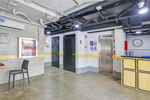 um quarto com uma cadeira e uma porta preta em Spot On Classy Bunkbeds Near Makati Manila Formerly MYTOWN Madrid em Manilla