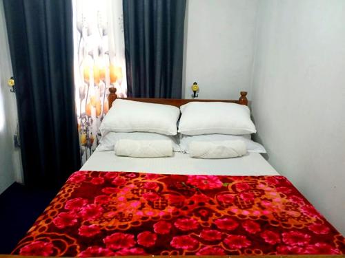 a bed with a bunch of red roses on it at Dio Green House NUWRA ELIYA in Nuwara Eliya