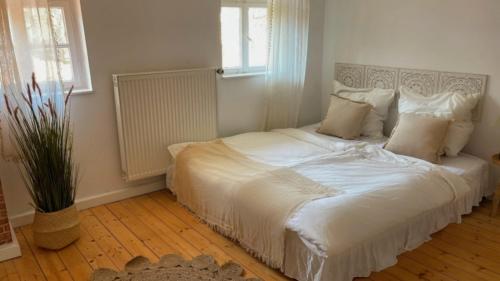 a bedroom with a large bed with white sheets and pillows at Fachwerkstube in Witzenhausen