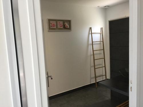 a room with a ladder and a white wall at Chambres d'Hôtes Le Mas du Bijou Bleu in Puget-sur Argens
