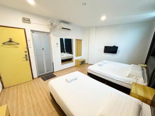 a hotel room with two beds and a television at Hotel O Furich Hotel in Mentekab