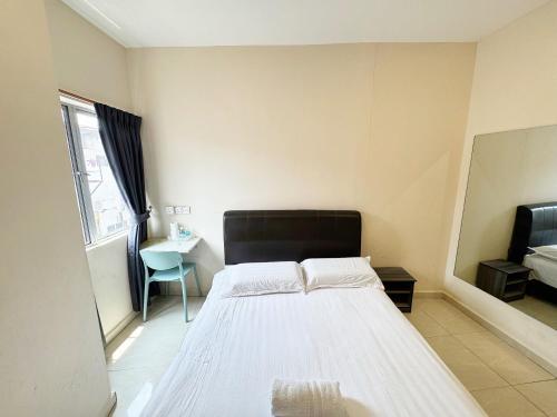 a bedroom with a bed and a chair in it at Hotel O Furich Hotel in Mentekab