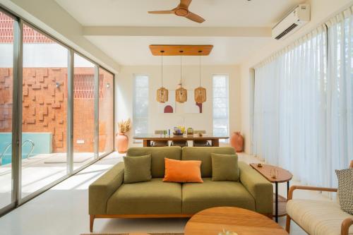 a living room with a green couch at ELIVAAS Mirai Aries 3 BHK Retreat With Private Pool Near Famous Beaches in Vagator