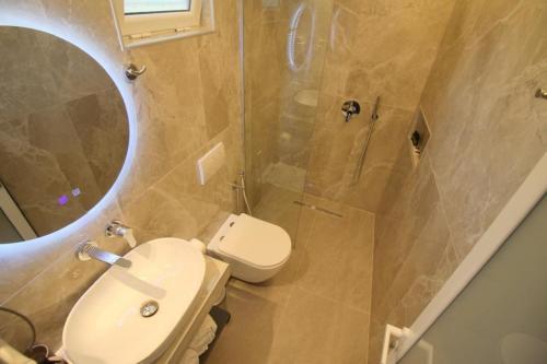 a bathroom with a toilet and a shower with a mirror at Vila Murati in Ksamil