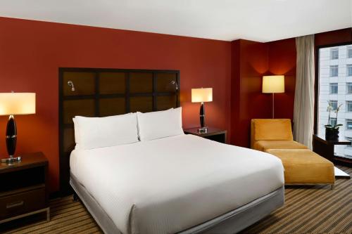 a bedroom with a large white bed and a chair at Renaissance Caracas La Castellana Hotel in Caracas