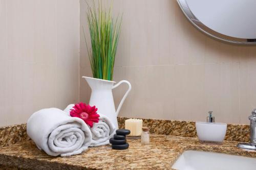 a bathroom counter with a towel and a vase at Renaissance Caracas La Castellana Hotel in Caracas