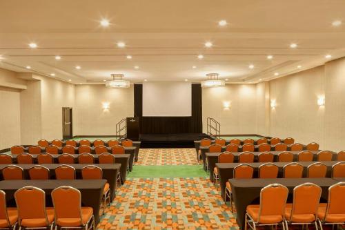 an empty hall with orange chairs and a stage at Renaissance Caracas La Castellana Hotel in Caracas