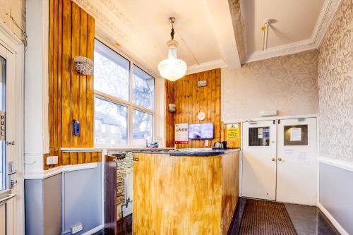 a kitchen with wooden walls and a large window at London Shelton Hotel, Finsbury Park in London