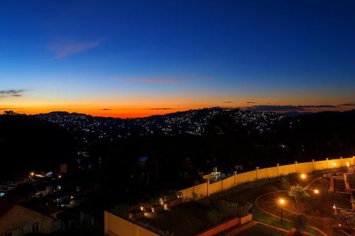a view of a city at night with lights at The Aston Executive Suite 2BR Balcony Near Mines View Baguio in Baguio