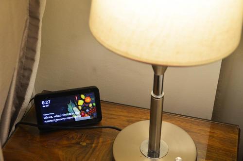 a cell phone sitting on a table next to a lamp at The Aston Executive Suite 2BR Balcony Near Mines View Baguio in Baguio