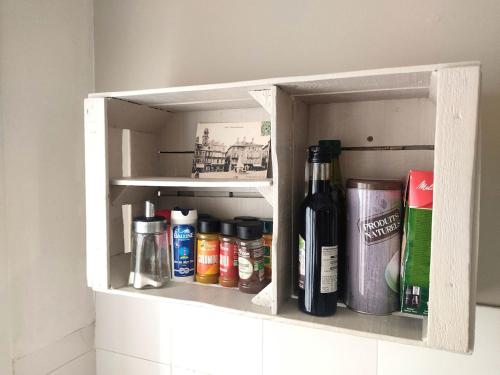 a shelf in a kitchen with bottles and cans at Le Petit Studio in Gap