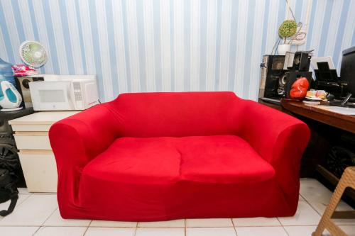 a red couch sitting in a living room at Super OYO Capital O Deroyal Sentra Timur in Jakarta