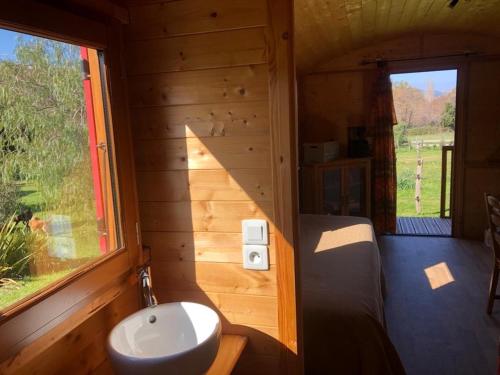 - une salle de bains pourvue d'un lavabo dans une cabine en bois dans l'établissement Le nid des crinières vagabondes, à Oletta