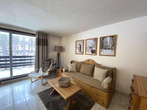 un salon avec un canapé et une table dans l'établissement Résidence Prapelier - Appartement chaleureux style montagne, situé dans un secteur calme au pied des pistes MAE-5501, à Vénosc