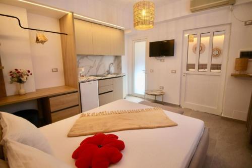 a bedroom with a white bed with a red flower on it at Vila Murati in Ksamil