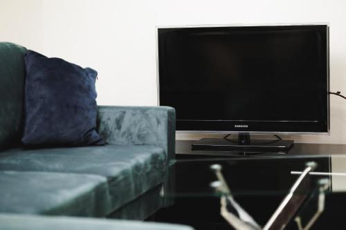 a living room with a couch and a flat screen tv at Dom v stráni in Poniky