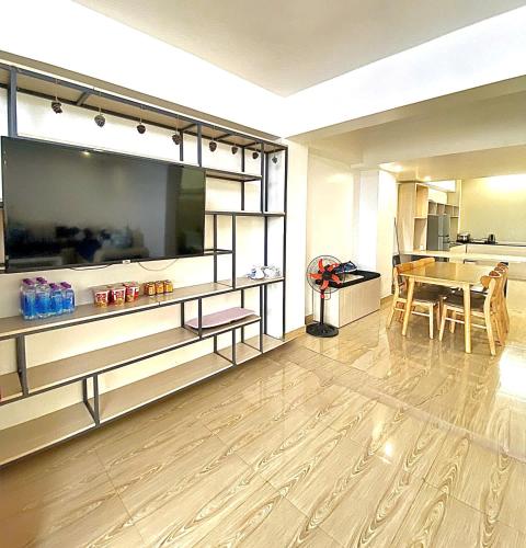 a living room with a large television and a table at Cosy Hotel & Apartment Dalat in Da Lat