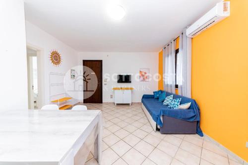 a living room with a blue couch and a yellow wall at Alice Flat - SAN FOCA in San Foca