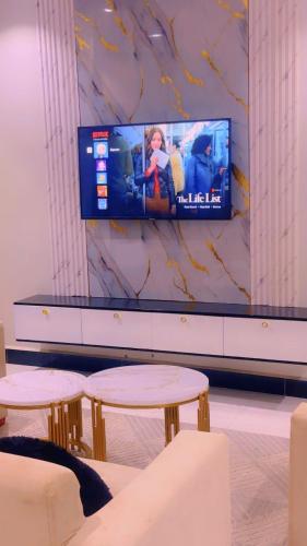 a room with two tables and a tv on a wall at AHWERA Beautiful Homes in Kampala
