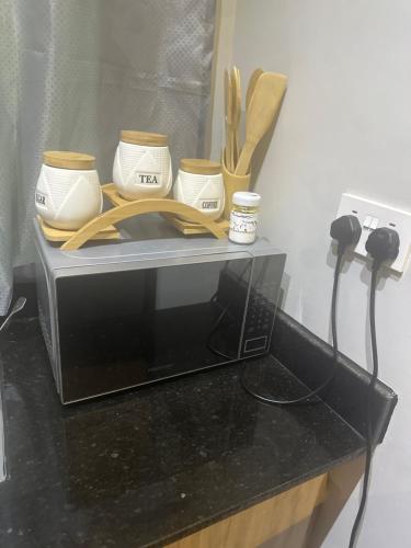 a microwave with bowls and utensils on top of it at AHWERA Beautiful Homes in Kampala