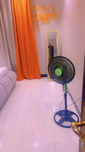 a living room with a fan on the floor at AHWERA Beautiful Homes in Kampala