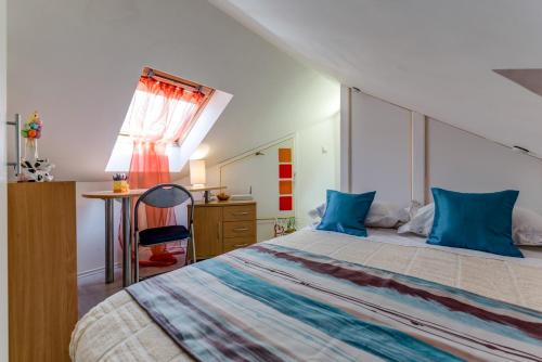 a bedroom with a bed with blue pillows and a desk at Apartment sea view Mouth Cetina in Omiš