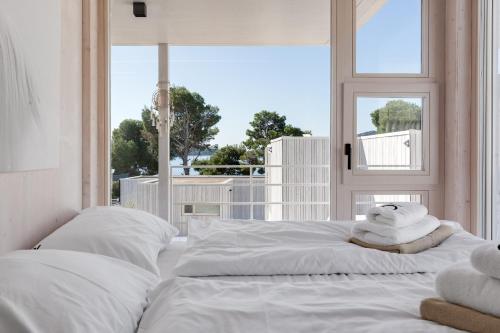 two beds in a room with a window at Zalo Villa Buqez in Drage