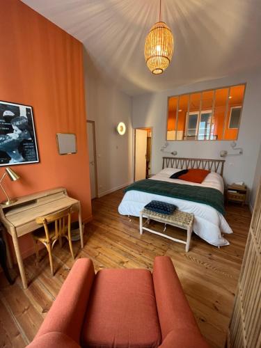 - une chambre avec un lit aux murs orange et un canapé dans l'établissement Maison d'hôtes Alma, à Bordeaux
