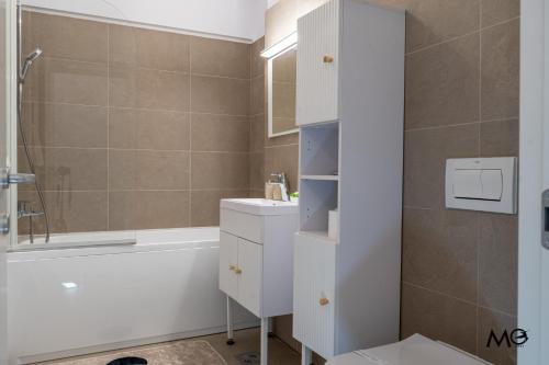 un bagno con vasca, lavandino e WC di MoHost Noua 3 - Premium Escape with Balcony Views a Braşov