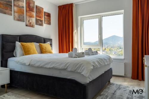una camera da letto con un letto grande con una grande finestra di MoHost Noua 3 - Premium Escape with Balcony Views a Braşov