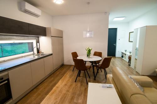 a kitchen and living room with a table and a couch at Apartments Villa Prod in Ljubljana