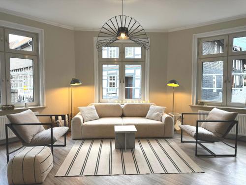 a living room with a couch and two chairs at HYGGE LIVING - Große hochwertige Apartments - hundefreundlich - Boxspringbetten - inmitten der Altstadt in Goslar