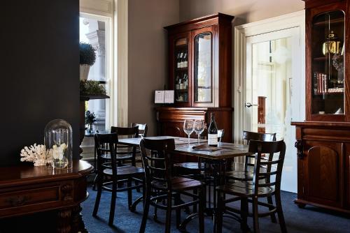 a dining room with a table and chairs with wine glasses at The Royal Queenscliff in Queenscliff