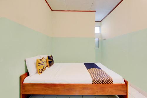 - un petit lit dans un dortoir aux murs blancs dans l'établissement Hotel O Pondok Wisata Kaliandra Kaliurang, à Yogyakarta
