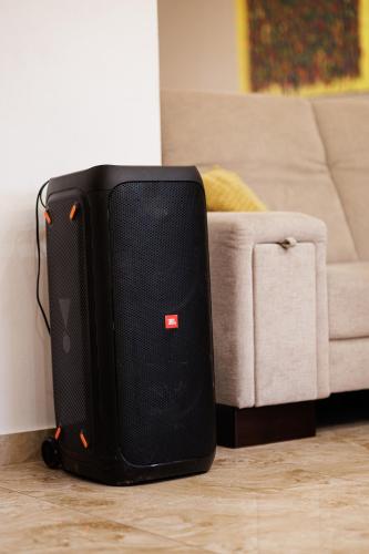 a black speaker sitting on the floor next to a couch at Dom v stráni in Poniky