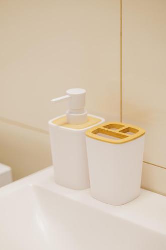 two white containers sitting on a counter in a bathroom at Dom v stráni in Poniky