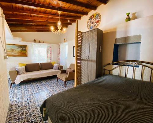 a bedroom with a bed and a couch in a room at Badehan Guest House in Cesme