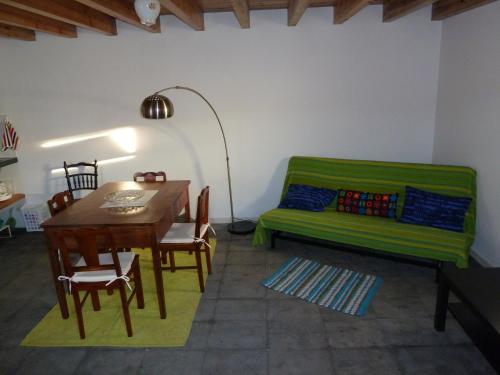 a living room with a green couch and a table at Casas Alto da Bonança in São Roque do Pico