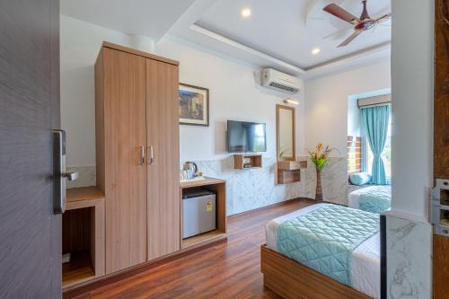 a hotel room with a bed and a tv at Salcete Beach Resort in Colva
